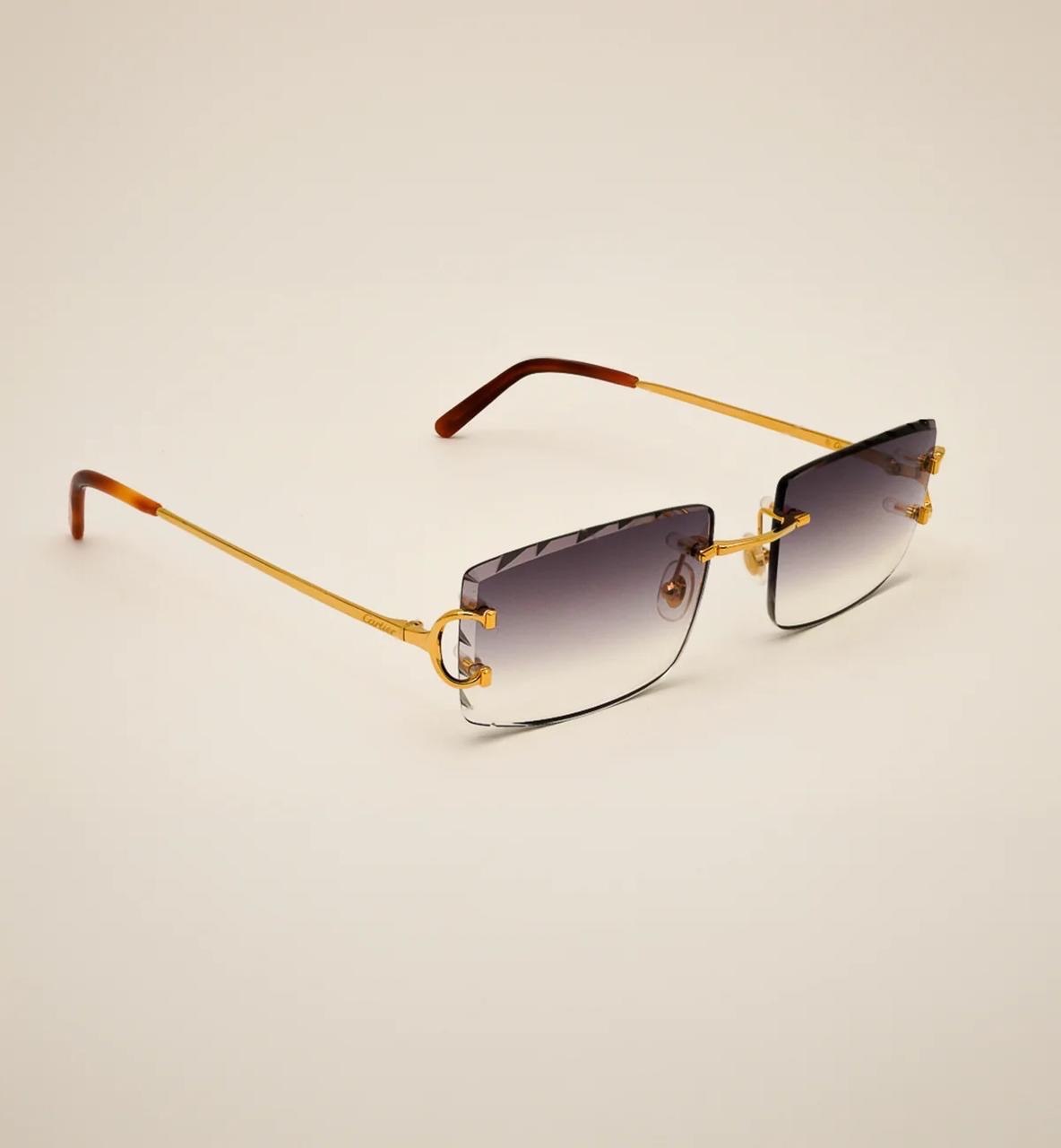 Gold-toned sunglasses against a pale backdrop
